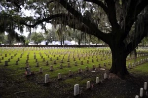 American flags fly in front of gravesites of U.S. soldiers.